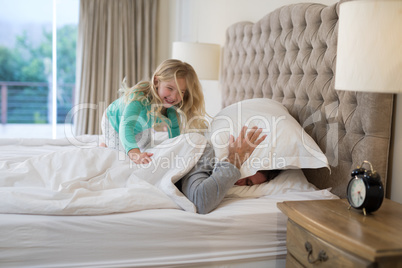 Father and daughter having fun on bed