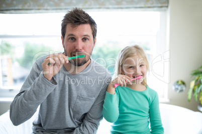 Father and daughter brushing teeth in the bathroom