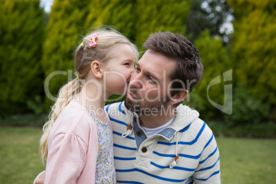 Young girl kissing her father