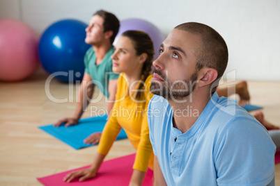 Yoga instructor guiding students in practicing cobra pose