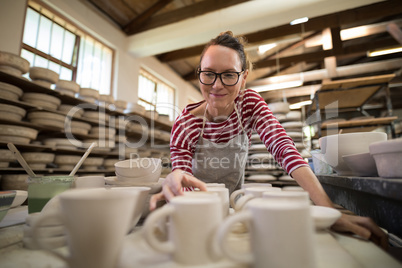 Woman checking mugs at worktop