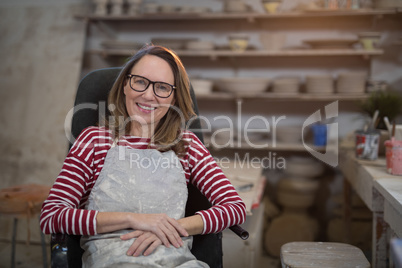 Female potter relaxing on chair