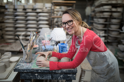 Portrait of woman checking mugs at worktop