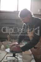 Male potter molding a clay