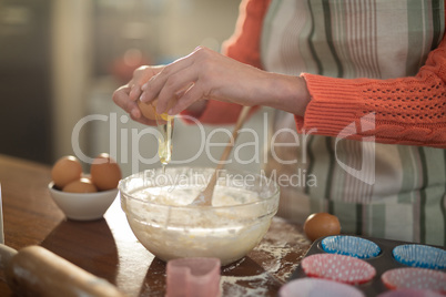 Woman breaking an egg Into bowl