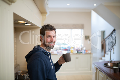 Man holding a cup of coffee at home