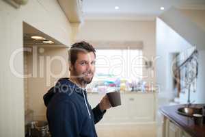 Man holding a cup of coffee at home