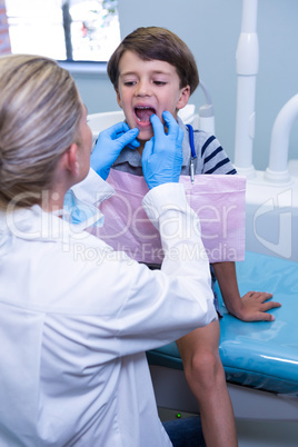 Dentist examining boy at dental clinic