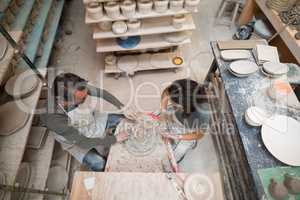 Overhead of male potter assisting female potter