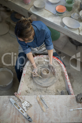 Overhead of female potter molding a clay