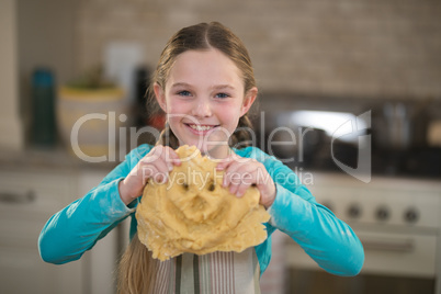 Smiling girl holding dough in kitchen Smiling girl holding dough in kitchen