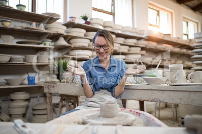 Excited female potter molding a clay