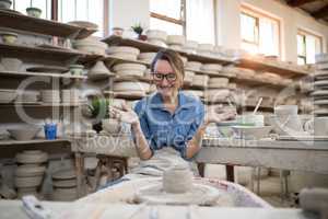Excited female potter molding a clay