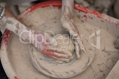 Male potter molding a clay