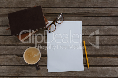 Organizer, coffee, spectacles, pencil and paper on wooden plank