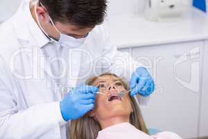 Dentist examining woman at dental clinic