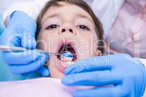 Dentist examining cute boy at clinic