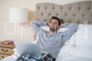 Man using laptop in bed