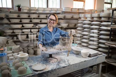 Portrait of female potter standing at worktop