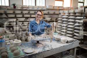 Portrait of female potter standing at worktop