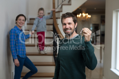 Man holding house key while sitting on stairs