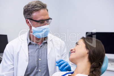 Dentist talking with woman at clinic