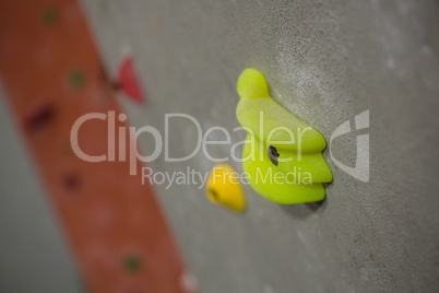 Close up of green hand grip on wall in studio