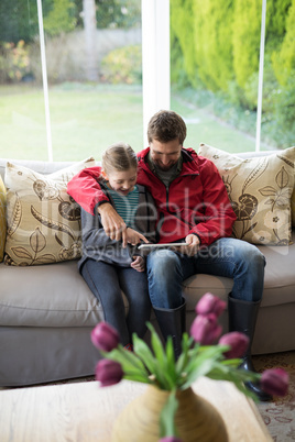 Father and daughter using digital tablet