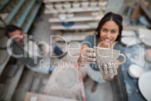 Female potter holding clay cup