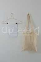 Paper and bag hanging against white wall