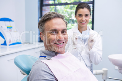 Portrait of man sitting on chair by dentist