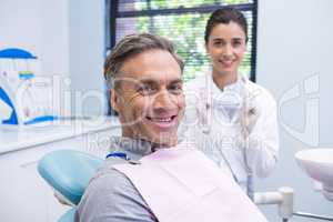 Portrait of man sitting on chair by dentist
