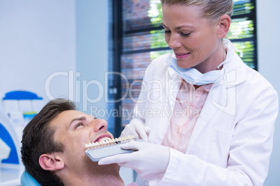 Dentist holding equipment while examining patient at medical clinic