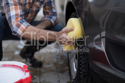 Man washing a car on a sunny day