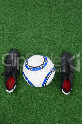 Football and cleats on artificial grass