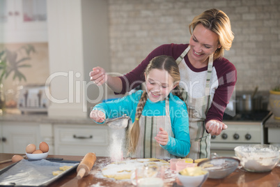 Mother and daughter preparing cookies in kitchen