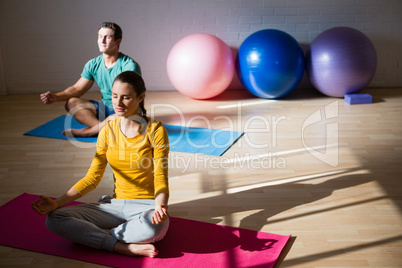 People meditating in lotus position health club