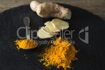 Turmeric powder and ginger on board