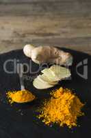 Turmeric powder and ginger on board