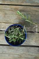 Rosemary in bowl on wooden table