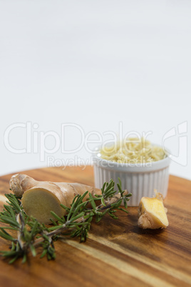 Close up of rosemary and ginger on wooden serving board