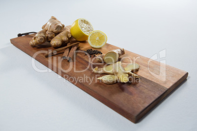 High angle view of lemon and various spices on wooden serving board