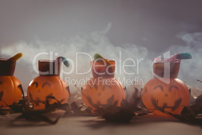 Food in jack o lantern containers with autumn leaves during Halloween