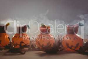 Food in jack o lantern containers with autumn leaves during Halloween