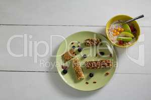 Granola bars and fruit cereal on white background