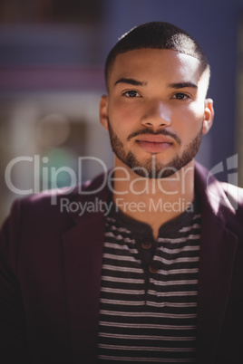 Portrait of confident young man wearing maroon blazer