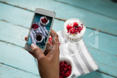 Hands taking photo of breakfast with mobile phone