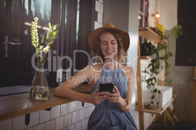 Smiling young woman using smartphone