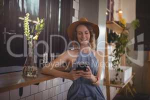 Smiling young woman using smartphone