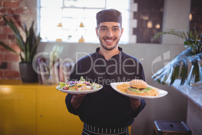 Portrait of smiling young waiter serving fresh food